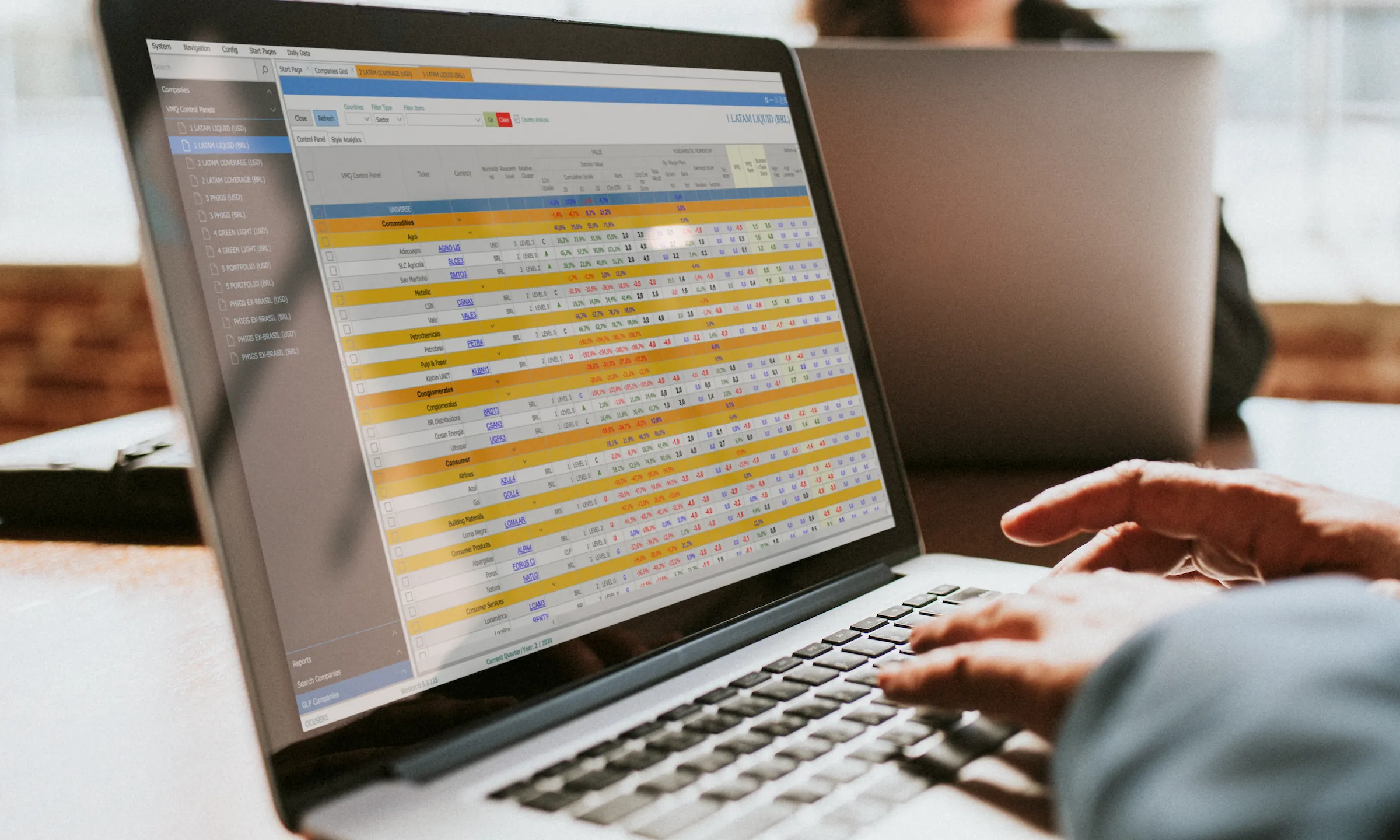 The old research tool: a dense colour-coded spreadsheet on a laptop, the Excel-era apparatus being replaced